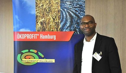 Mitarbeiter vor dem Ökoprofit Logo - Copyright: Claudia Marxen